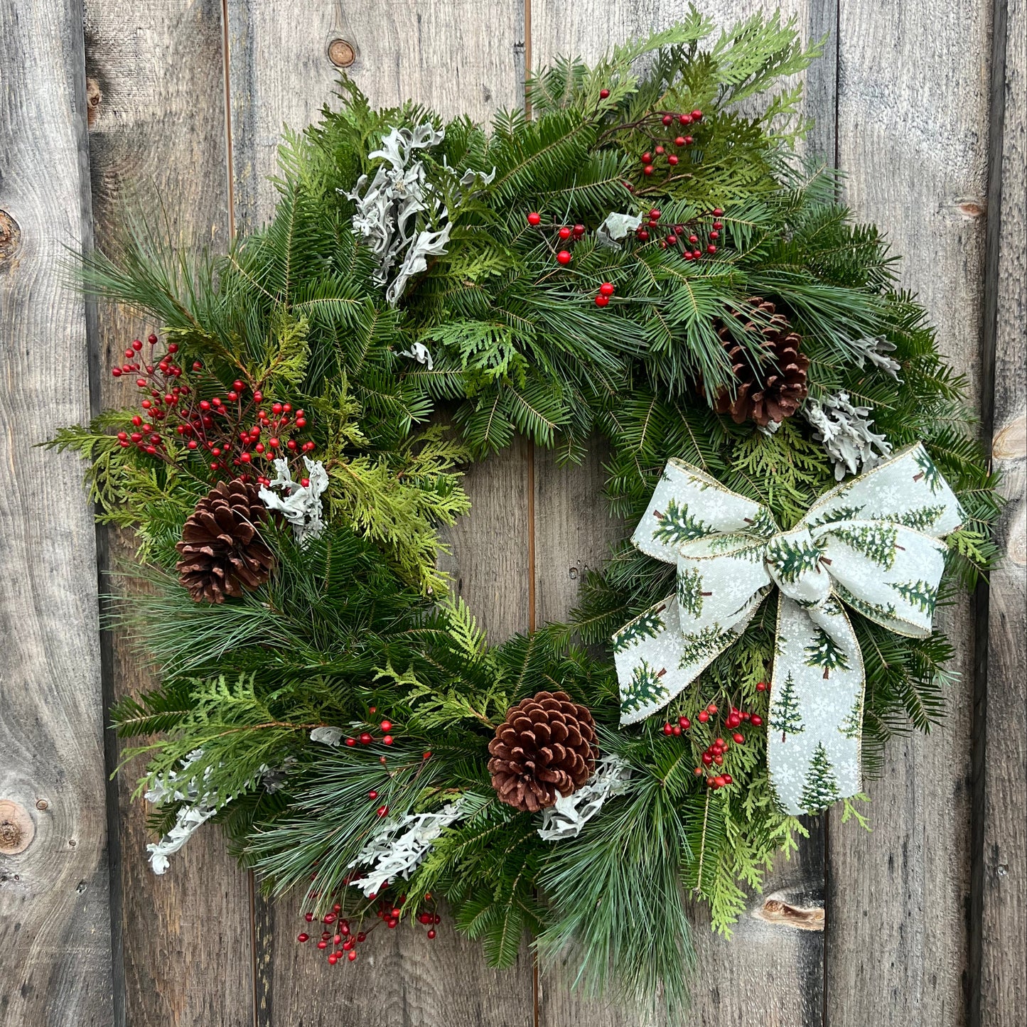 Christmas wreath with a white bow on a wooden background
