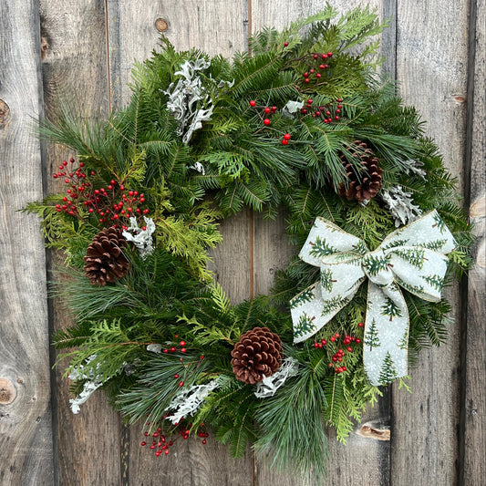 Christmas wreath with a white bow on a wooden background